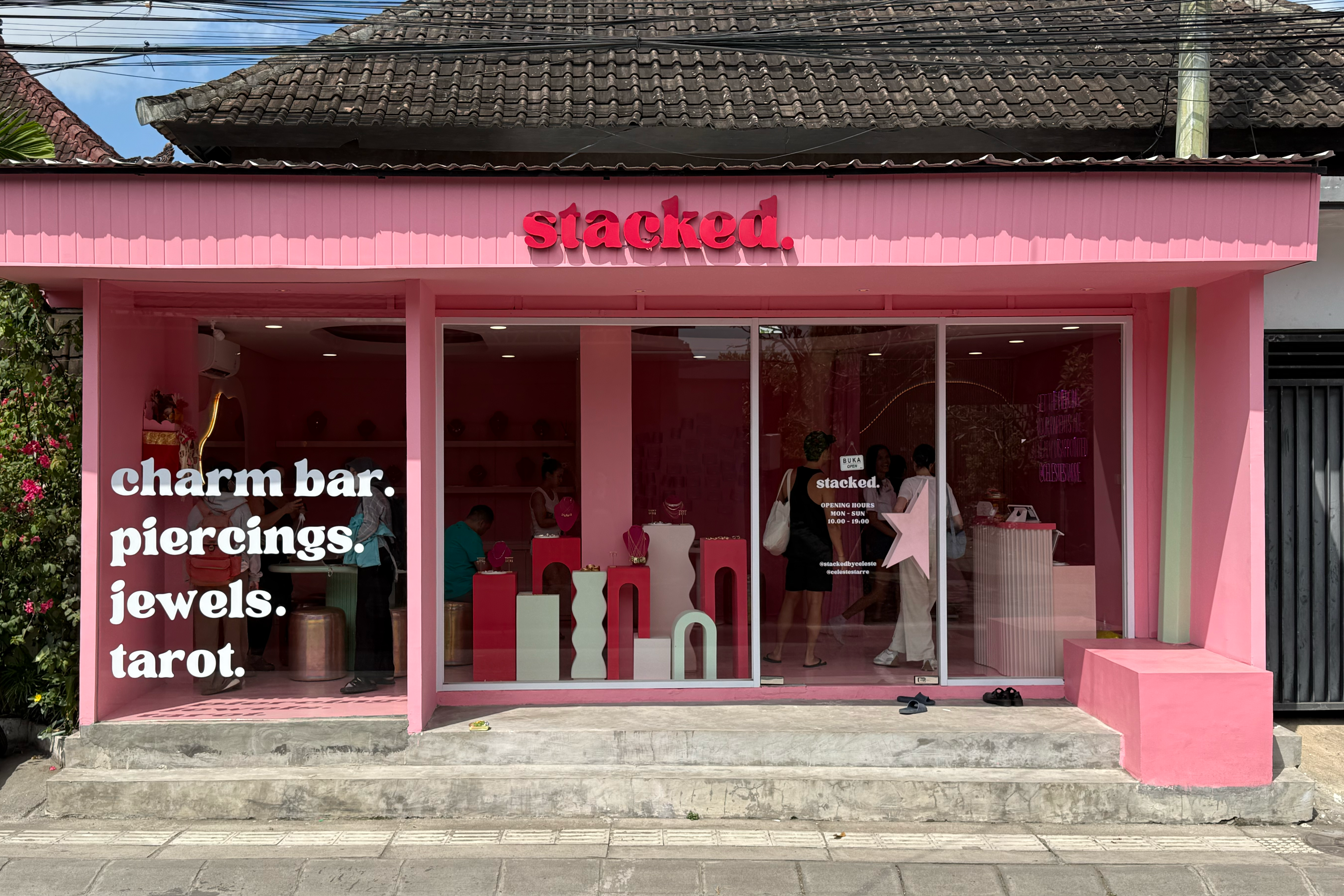 Pink store front with 'Stacked' branding and window display.