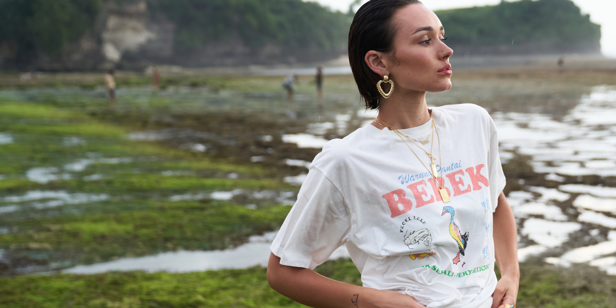 Woman wearing a white t-shirt with text and graphics outdoors
