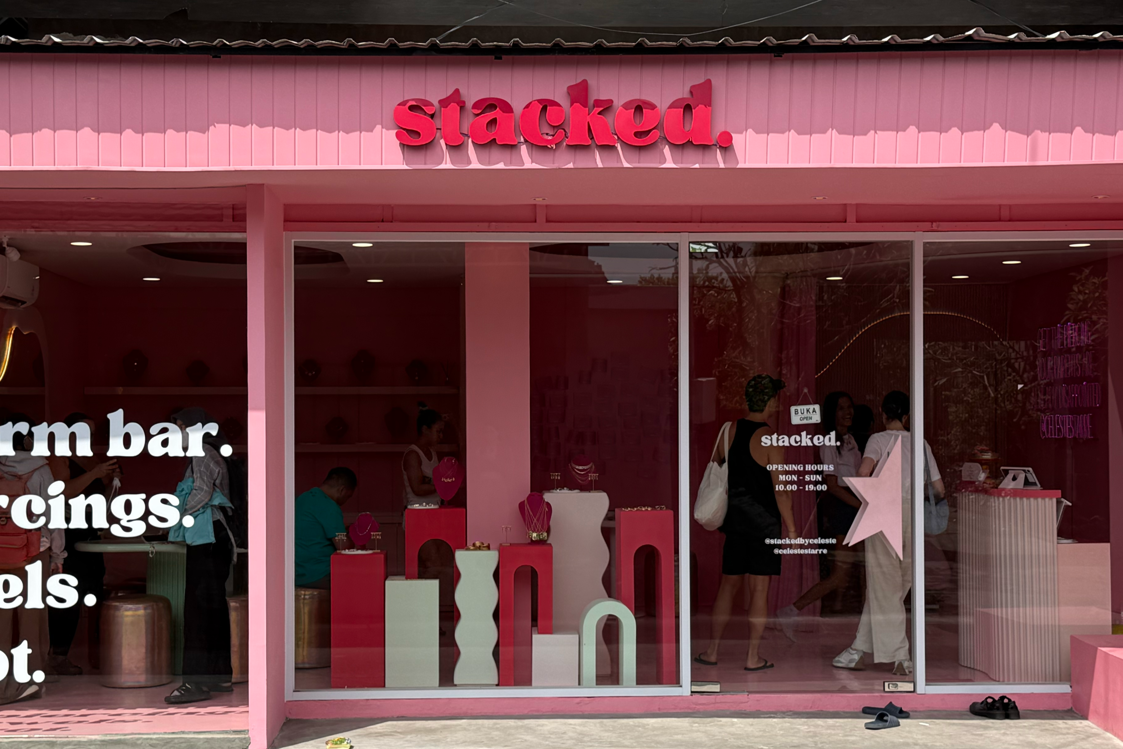 Pink store front with 'Stacked' branding and window display.